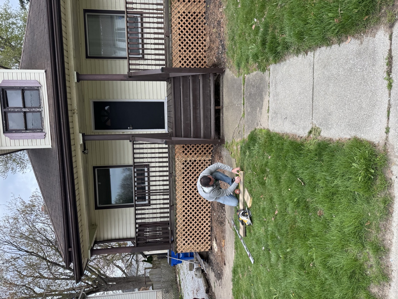 Front porch with a new railing and steps, lawn freshly cut