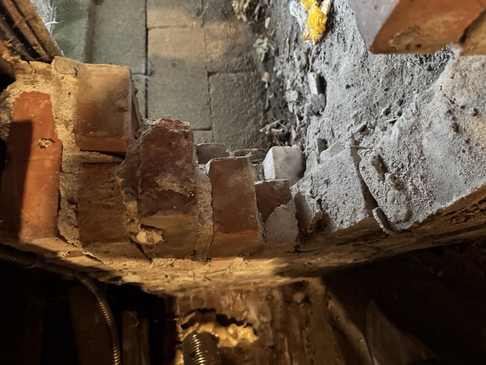 Rotted sill plate and crumbling brick at the base of an old house