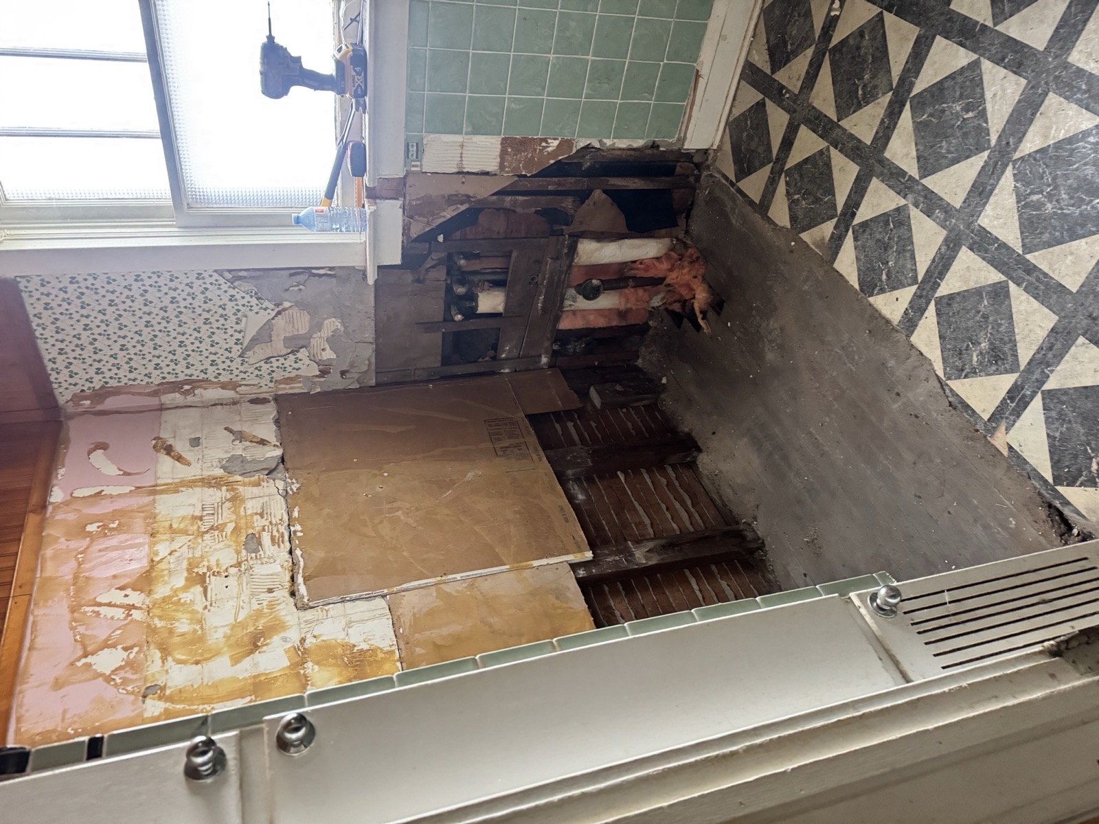 Bathroom gutted to the studs, original checkerboard floor still down