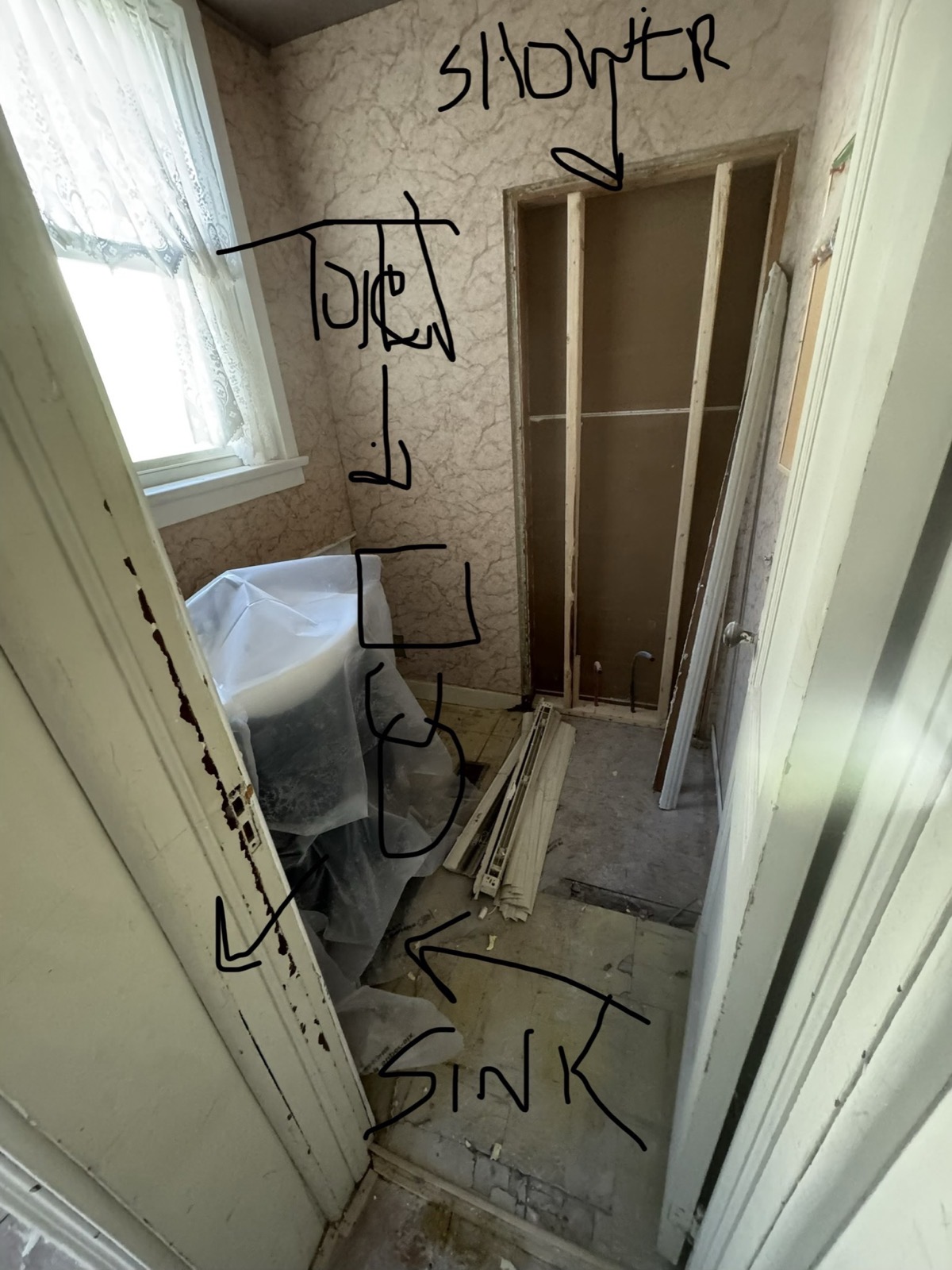 Shower, toilet and sink positions written in marker on new drywall
