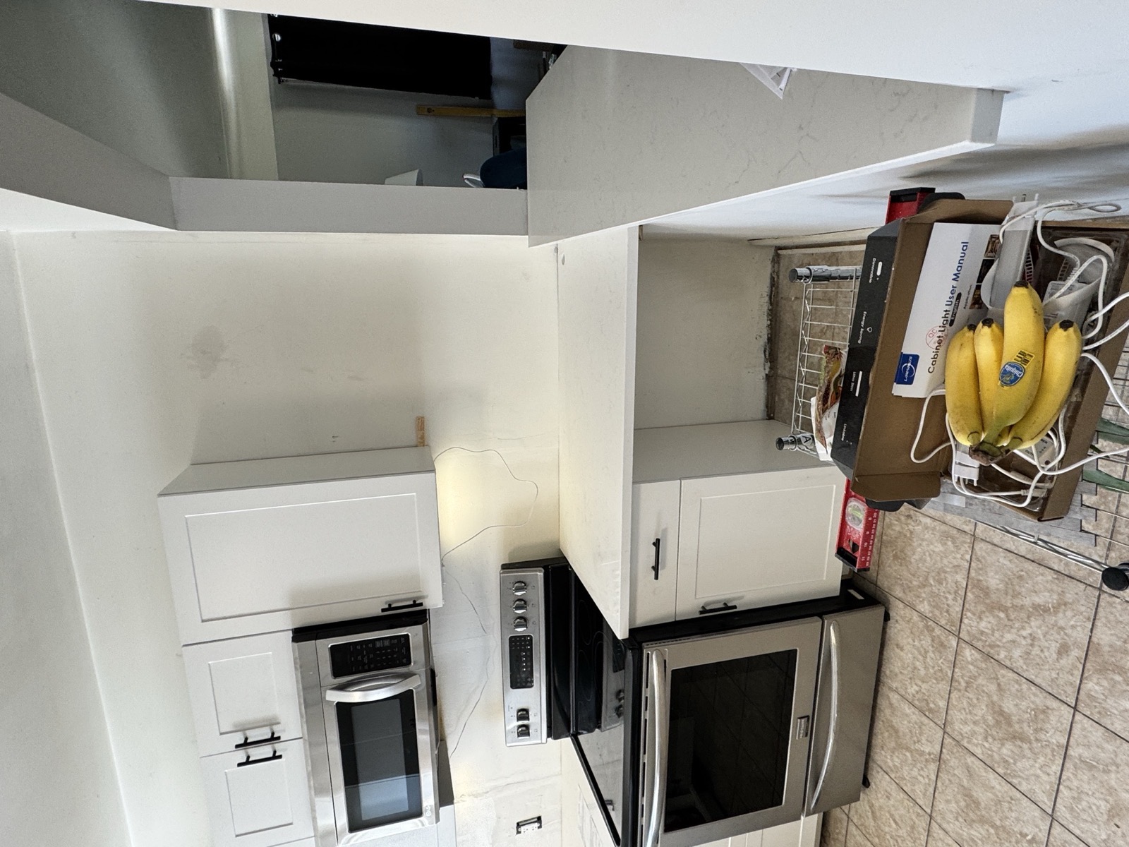 Finished pass-through kitchen with white cabinets and quartz counters