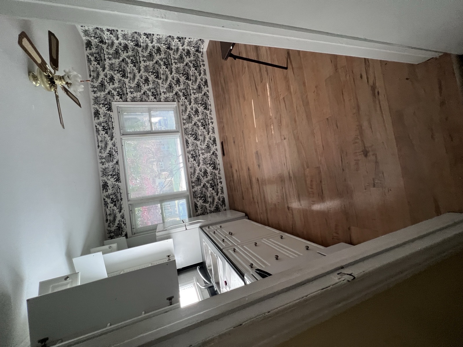 Wallpapered kitchen with original hardwood, as the family left it
